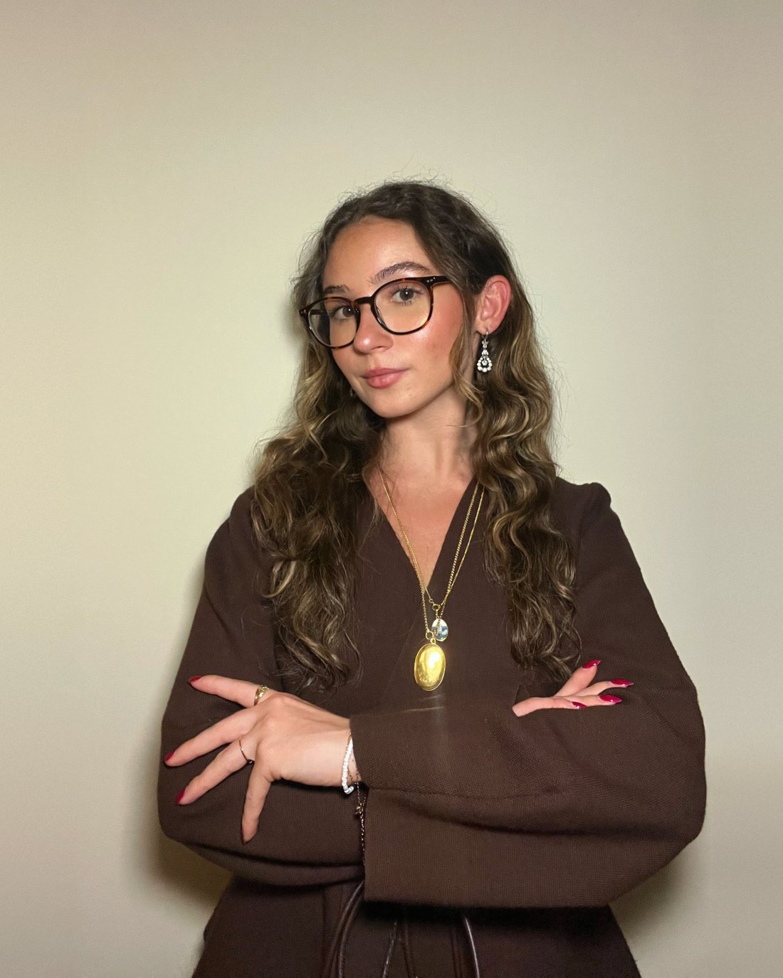 Retrato da Rita Sousa, de óculos e camisola castanha, de braços cruzados